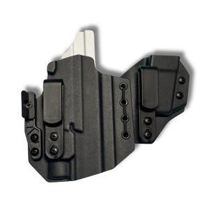 Op de afbeelding: Zwarte polymeer holster met twee zwarte clips en een witte accent. De holster heeft een gegoten ontwerp met meerdere schroefpunten en een reeks oogjes verbonden door een zwart koord. De clips zijn ontworpen voor bevestiging aan de riem.