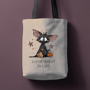 Peut inclure: Sac fourre-tout beige avec un dessin de chauve-souris de dessin animé tenant un seau de bonbons en forme de citrouille et un sac de friandises. Le texte "BAT-TER BE READY FOR CANDY" est imprimé en dessous, avec des étoiles. Sangles noires.