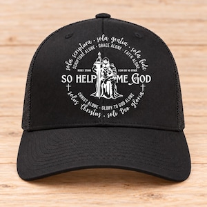 May include: A black trucker cap featuring a white graphic print of a knight kneeling with a sword. The design includes the text SO HELP ME GOD, HERE I STAND, I CAN DO NO OTHER, and various Latin phrases arranged in a circular pattern around the central figure.