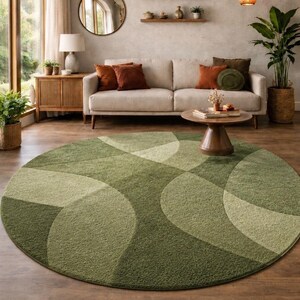 May include: A living room scene featuring a large, round green rug with a geometric pattern. The rug is the focal point, complemented by a beige sofa, wooden furniture, and decorative plants. The room has a warm, inviting atmosphere.