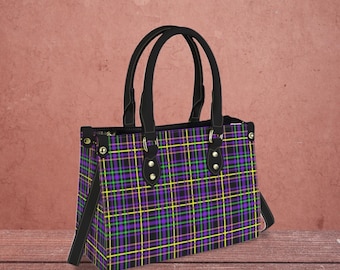 May include: A black tote bag with a purple, green, and yellow plaid pattern. The bag has a black leather handle and gold accents.
