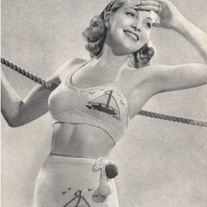 May include: A two-piece knitted bathing suit with a sailboat design. The suit is white with red and blue accents. The text on the image reads: "TWO-PIECE BATHING SUIT 7 ozs. of 3-ply, White 1 oz. Red; oz. Blue"