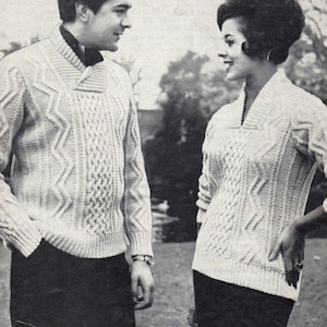 May include: A couple wearing matching white cable knit sweaters with a collared neckline. The sweaters have a diamond pattern.
