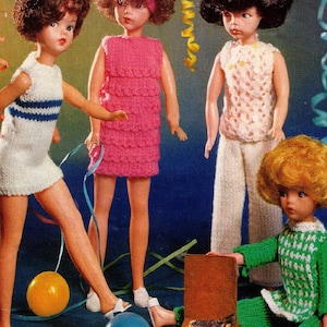 May include: Four dolls wearing knitted outfits. The dolls are dressed in a pink dress, a white top and trousers, a blue and white striped dress, and a green and white checked dress. The dolls are standing in front of a blue background with a record player and balloons.