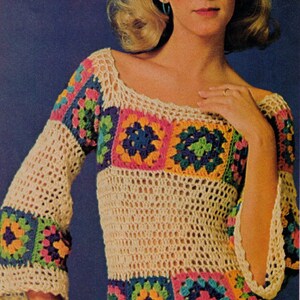 May include: Cream-colored crochet top with colorful square patterns on the sleeves and bodice. The squares feature vibrant hues of pink, blue, green, and yellow. The top has a scoop neckline and bell sleeves. The text "BritKnits Vintage" is visible at the bottom.