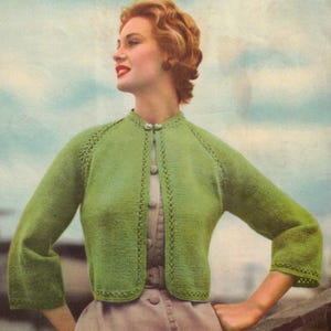 May include: Vintage green knitted bolero jacket with a round collar and three-quarter sleeves. The jacket has a delicate lace trim along the edges and fastens with a single button. The image includes the text "BritKnits Vintage".