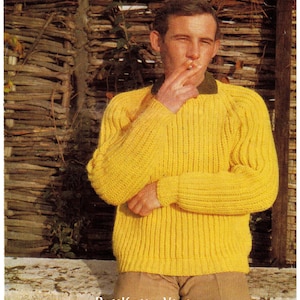 Könnte beinhalten: Ein gelber Strickpullover mit Rundhalsausschnitt und langen Ärmeln. Der Pullover hat eine gerippte Struktur.