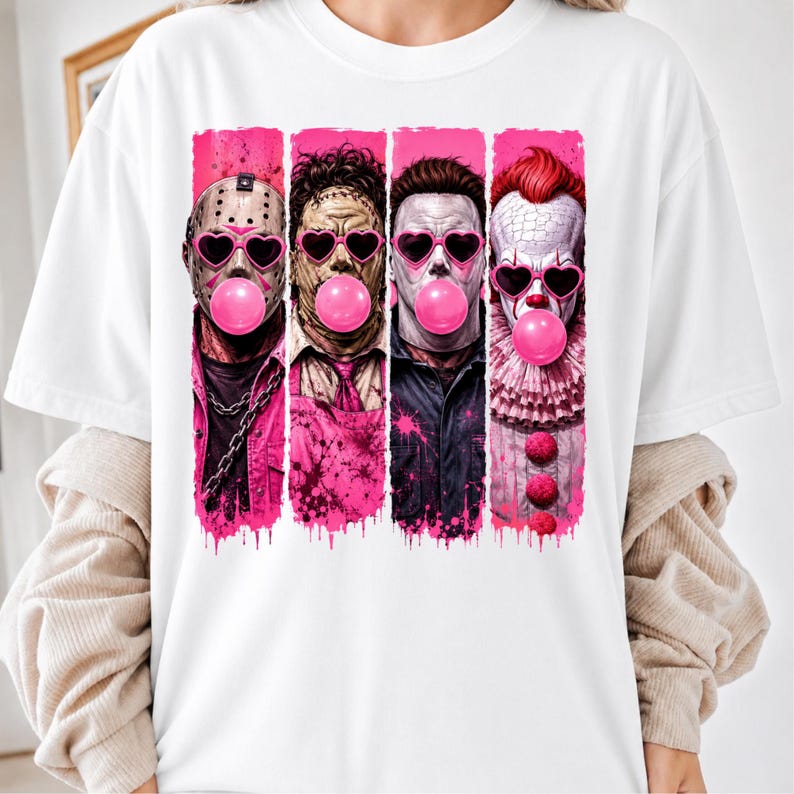 May include: A white t-shirt featuring a graphic print of four horror movie characters arranged in vertical panels. Each character wears pink heart-shaped sunglasses and blows a bright pink bubblegum bubble, set against a vibrant pink paint-splatter background.