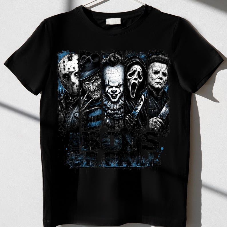 May include: A black short-sleeved t-shirt featuring a graphic print of five horror movie characters arranged in vertical panels. The design includes blue paint splatter accents and the text "BOYS OF FRIGHT" in a distressed, dark blue font.