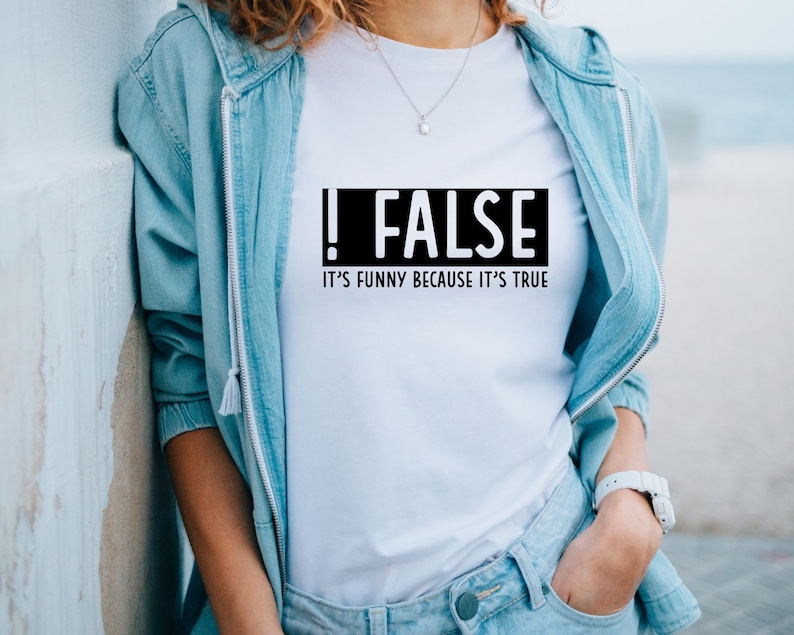 May include: White t-shirt with a black box that says "!FALSE" and "IT'S FUNNY BECAUSE IT'S TRUE" underneath.