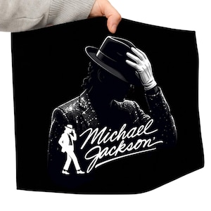 May include: Black graphic featuring a silhouette of Michael Jackson in a fedora and sequined jacket, with the text "Michael Jackson" in a stylized script. The image also includes a white silhouette of Jackson in a signature pose.