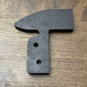 May include: Black plastic T-shaped bracket with two holes. The bracket has a rounded top and a flat bottom.