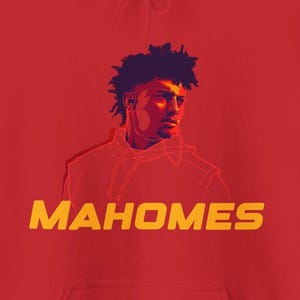 Puede incluir: Sudadera roja con un gráfico de una persona con un afro morado oscuro y la palabra "MAHOMES" en amarillo.