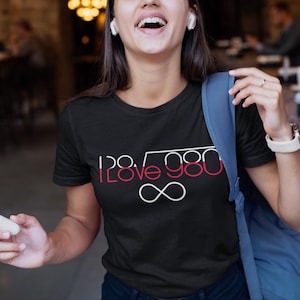 Peut inclure: Un t-shirt noir avec un graphique blanc et rouge qui dit "I 28√980 I LOVE YOU ∞".