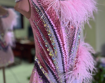 Op de afbeelding: Een roze maillot met een gelaagd ontwerp van strass en veren. De maillot is mouwloos en heeft een ronde hals. De maillot is versierd met roze veren rond de halslijn en de onderkant van de maillot.