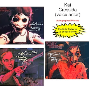 Puede incluir: Fotos autografiadas de Kat Cressida, actriz de doblaje. Las imágenes presentan personajes de videojuegos, con firmas y texto. Múltiples fotos disponibles para elegir.