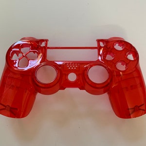 May include: A transparent red PlayStation 4 controller shell. The shell is made of clear plastic and has a red tint. The controller has all of the standard buttons and controls.
