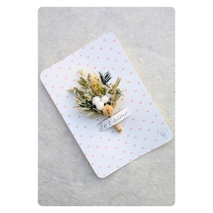 Carte fleurie "Je t'aime" sur un fond de petits coeurs