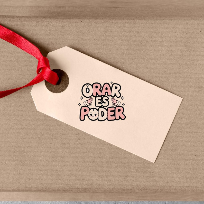 May include: A light pink and white gift tag with the text "ORAR ES PODER" in black lettering. The text is surrounded by two pink hands with a smiling face and white stars.