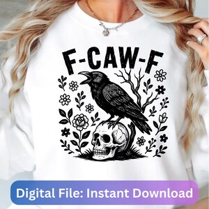 May include: White sweatshirt with a black graphic featuring a crow perched on a skull, surrounded by floral and botanical elements. The text "F-CAW-F" is above the crow. The bottom of the image has the text "Digital File: Instant Download".