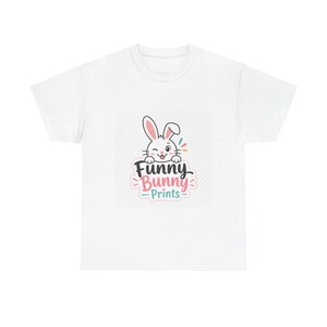 Peut inclure: T-shirt blanc avec un lapin de dessin animé qui fait un clin d'œil, avec le texte "Funny Bunny Prints". Le design comprend des accents colorés, parfait pour Pâques ou les tenues décontractées. Un t-shirt graphique amusant et fantaisiste.