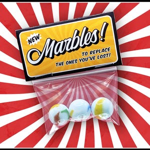 May include: A pack of marbles with a retro design. The package contains three colourful marbles in a clear plastic bag. The packaging has the words "New Marbles! To Replace The Ones You've Lost!" on a yellow and black background.