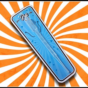 May include: A clear plastic pipette in a blue and white package with the text "MY FIRST pi-Pet-te". The package has a cartoon face and heart accents, set against an orange and white striped background.