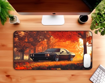 May include: A black muscle car mousepad featuring a classic car design set against a vibrant autumn forest backdrop. The car is the focal point, with a detailed rendering of the vehicle. The background features trees with red and orange leaves.