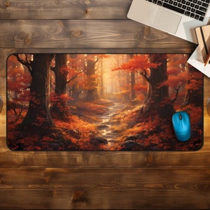 Pode incluir: Um tapete de rato com uma pintura digital de um caminho na floresta com folhas de outono e um riacho que o atravessa. O caminho leva a uma luz brilhante à distância.