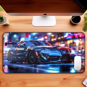 May include: A black sports car with a white racing stripe and a black mouse pad with a city night scene.