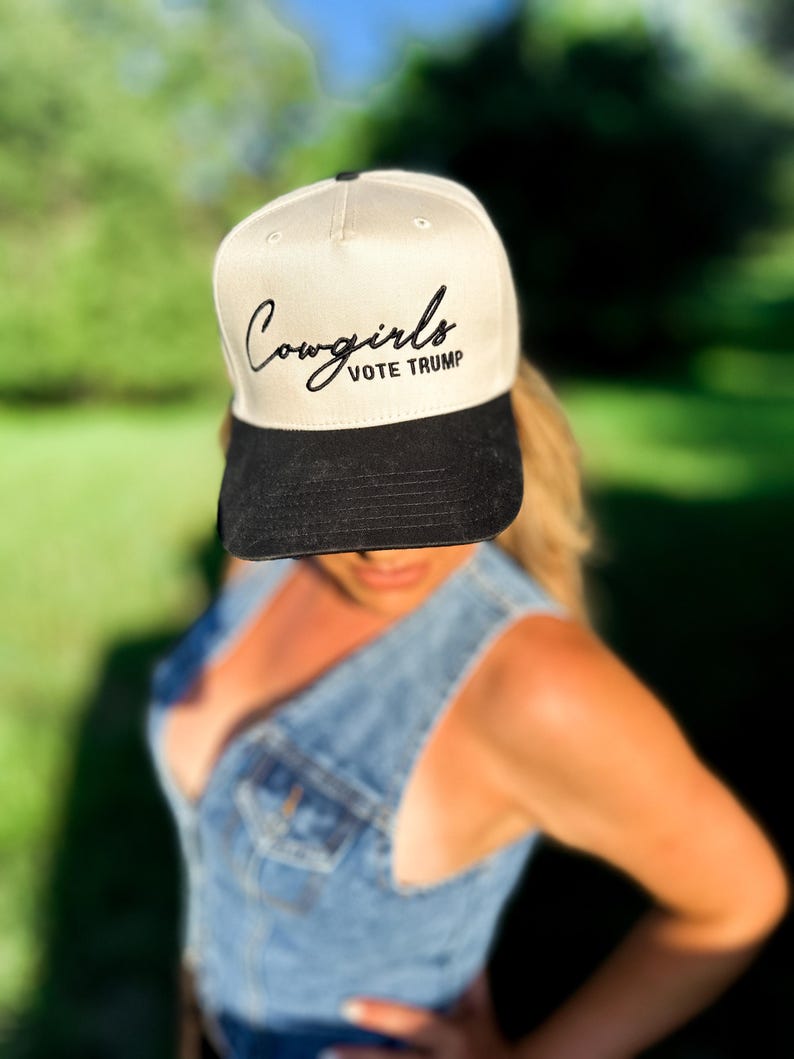 K&ouml;nnte beinhalten: Eine beige und schwarze Baseballkappe mit dem Text "Cowgirls VOTE TRUMP" in schwarzer Stickerei.