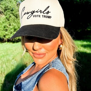 K&ouml;nnte beinhalten: Eine beige und schwarze Baseballkappe mit dem Text "Cowgirls Vote Trump" in schwarzer Stickerei.