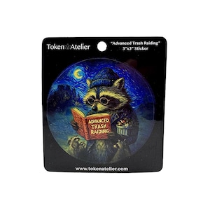 May include: A 3"x3" sticker featuring a raccoon wearing glasses and a hat, reading a book titled "Advanced Trash Raiding." The background depicts a starry night scene. The sticker has the "Token Atelier" logo and website address.