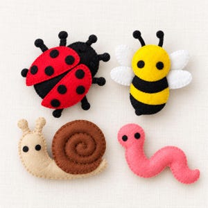 May include: Four felt animal appliques including a red and black ladybug, a yellow and black striped bee with white wings, a beige snail with a brown spiral shell, and a pink worm, all featuring simple black circular eyes.