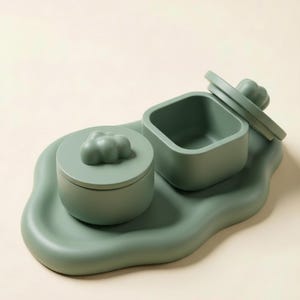 Puede incluir: Juego de servir de cerámica verde salvia. El juego incluye un recipiente redondo con tapa, un recipiente cuadrado y una bandeja con bordes ondulados. Las tapas tienen un asa en forma de nube. Para servir o almacenar.