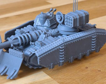 May include: A gray plastic model of a tank with a large cannon and a missile launcher on top. The tank has a shovel-like attachment on the front.