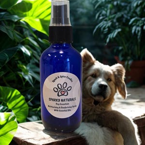 May include: A cobalt blue spray bottle with a black nozzle and a white circular label. The label features a paw print icon with a small heart and the text: Spark & Spice Candles, SPARKY NATURALS, Dog Essentials, Moisturising & Deodorising Spray With Essential Oils.