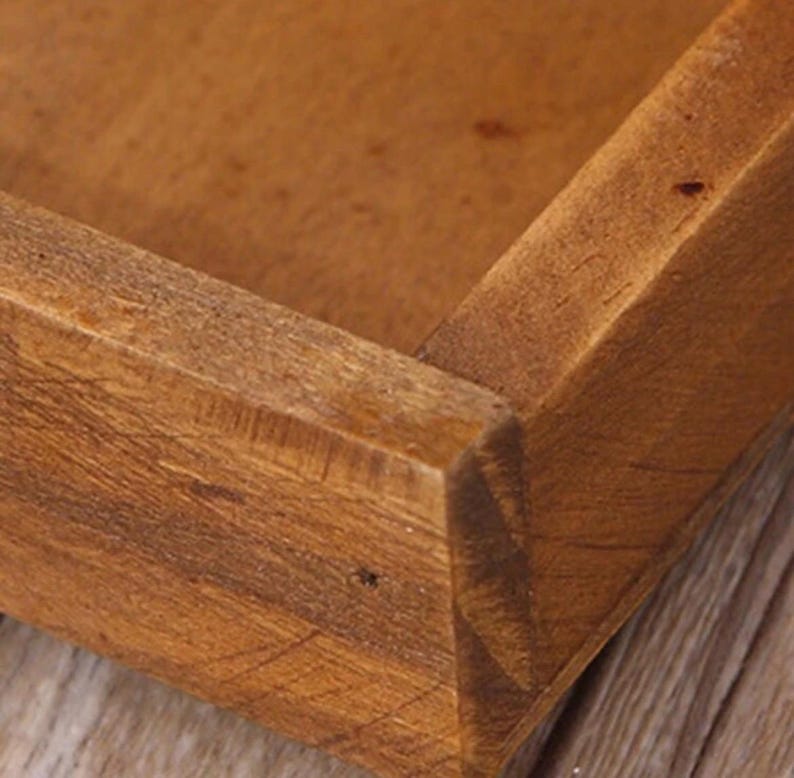 Close-up of a vintage wooden desk organiser showing solid wood corner joints and natural grain texture