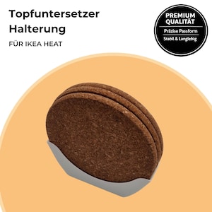 Könnte beinhalten: Ein Satz von vier runden, braunen Korkuntersetzern in einem weißen Halter. Die Untersetzer bestehen aus einem natürlichen, strukturierten Material. Der Text auf dem Bild lautet "Topfuntersetzer Halterung FÜR IKEA HEAT" und "PREMIUM QUALITÄT".