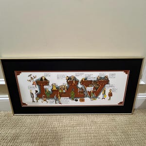May include: A framed cartoon print depicting the word "LAW" with various characters and scenes related to the legal profession. The print is set against a white background and framed in black with a gold trim.