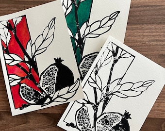 May include: Three black and white prints of a pomegranate branch with leaves and fruit. The prints are on white paper with a red, green, and white background.