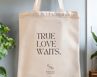May include: A white canvas tote bag with black text that reads "TRUE LOVE WAITS."  The bag also has a small circle with the letters "E & D" and the text "PUNTA CANA October 12, 2023".