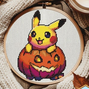 May include: A yellow Pikachu Pokemon character sitting on top of a carved orange and purple pumpkin with a jack-o-lantern face. The image is a cross-stitch pattern.