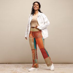 Puede incluir: Una mujer con una chaqueta vaquera blanca sobre un top beige y pantalones acampanados de patchwork de colores. Está sonriendo y de pie sobre un suelo de baldosas de color marrón claro.