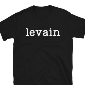 May include: Black t-shirt with the word "levain" printed in white on the front.