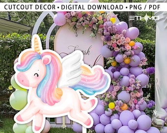 May include: A colourful unicorn cutout with a rainbow mane and wings. The unicorn is standing in front of a backdrop of purple balloons and flowers.