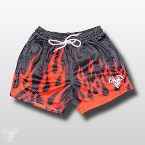 May include: Black mesh shorts with a red flame design. The shorts have a white drawstring and a white logo on the right leg. The shorts are designed for athletic wear.
