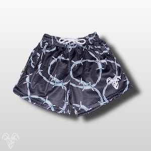 May include: Black mesh shorts with a white drawstring and a barbed wire pattern in light blue. A white logo is on the right leg. The shorts have a relaxed fit and are suitable for casual wear.
