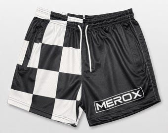 Könnte beinhalten: Sportshorts mit geteiltem Design, bestehend aus einem schwarz-weißen Karomuster auf der linken Seite und einfarbigem Schwarz auf der rechten Seite. Die Shorts haben einen weißen Kordelzug und den Schriftzug MEROX in einem weißen Kasten.