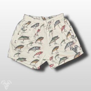 May include: White cotton shorts with a pattern of colorful fishing lures.